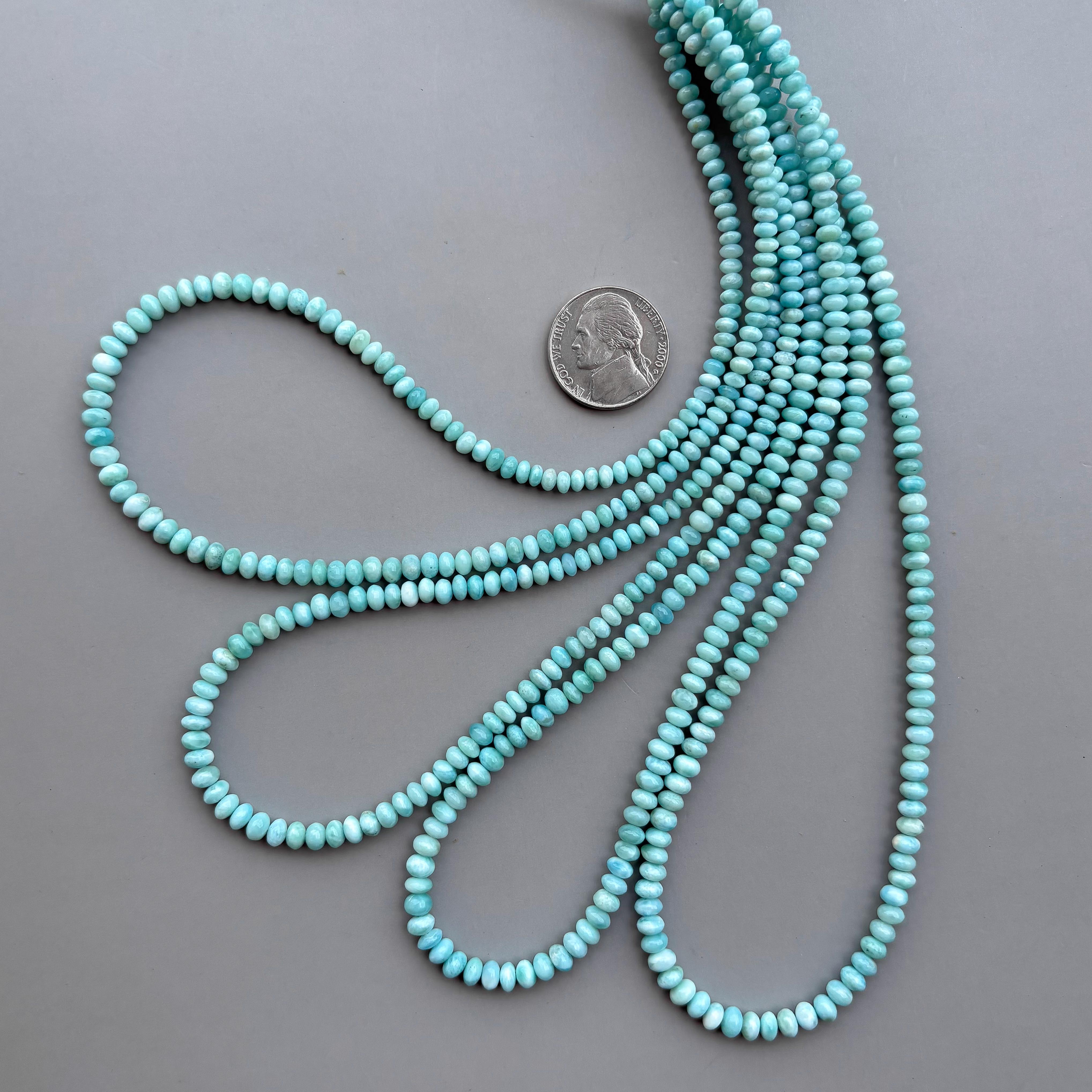 Larimar gemstone beads 4-5mm strand coiled on grey background