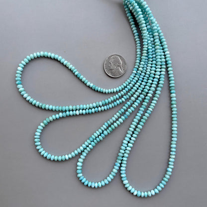 Larimar gemstone beads 4-5mm strand coiled on grey background
