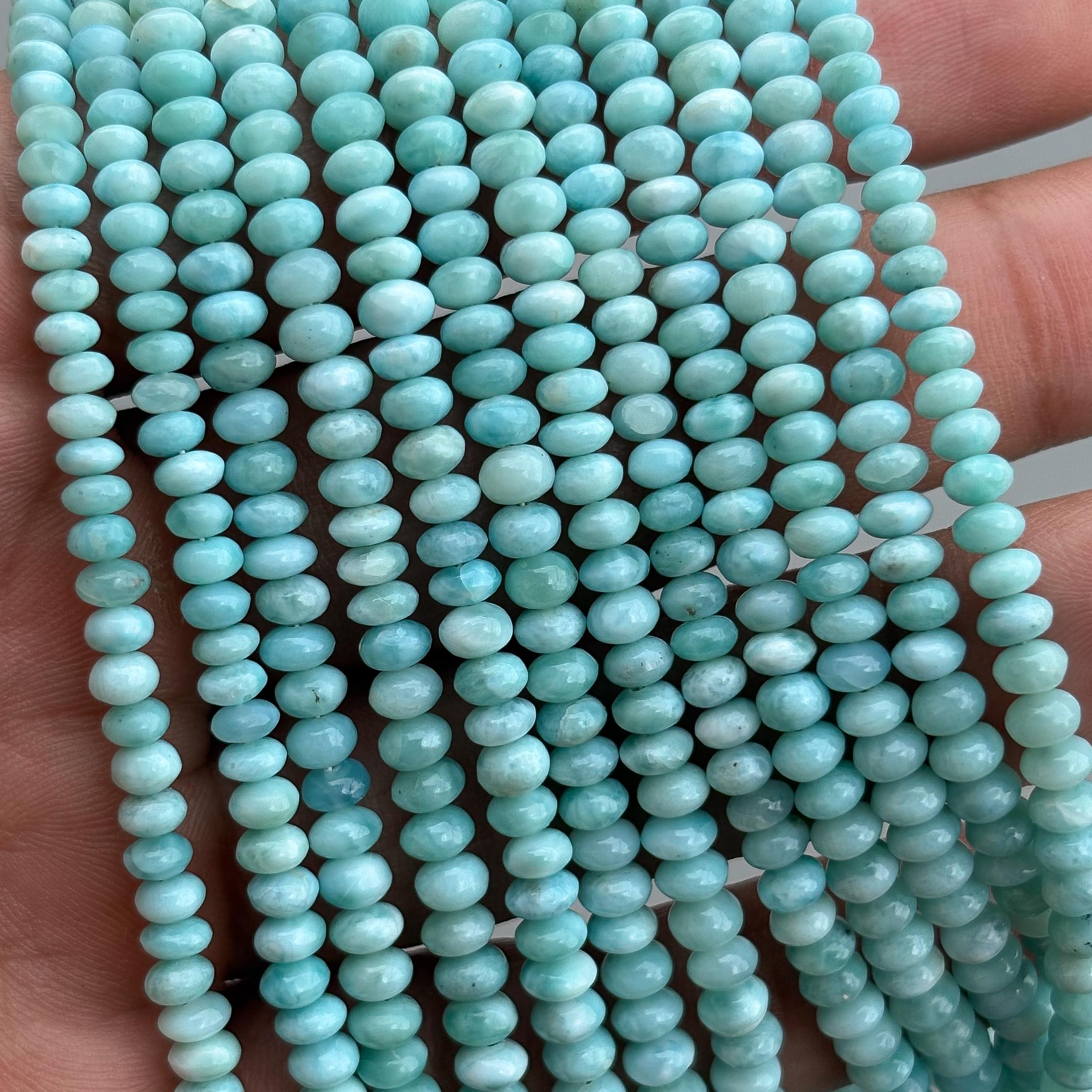 Natural Larimar smooth rondelle beads strand close-up showing blue and white patterns